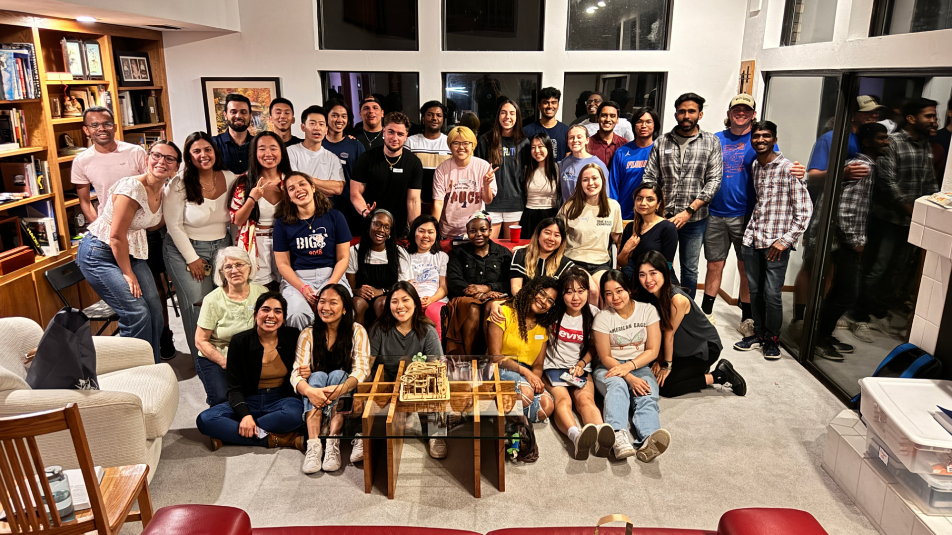 A diverse group of friends gathered together for a photo in a living room