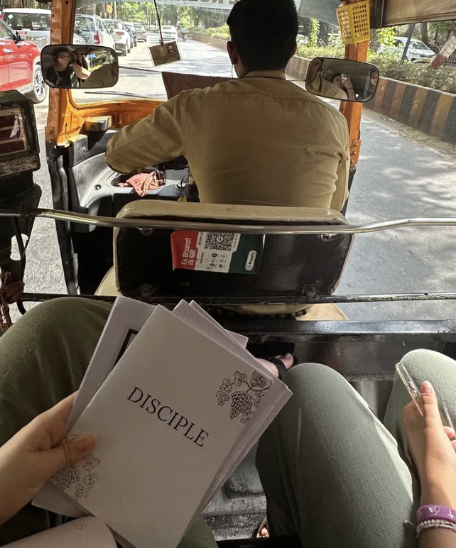 Two people in conversation over coffee and open notebooks