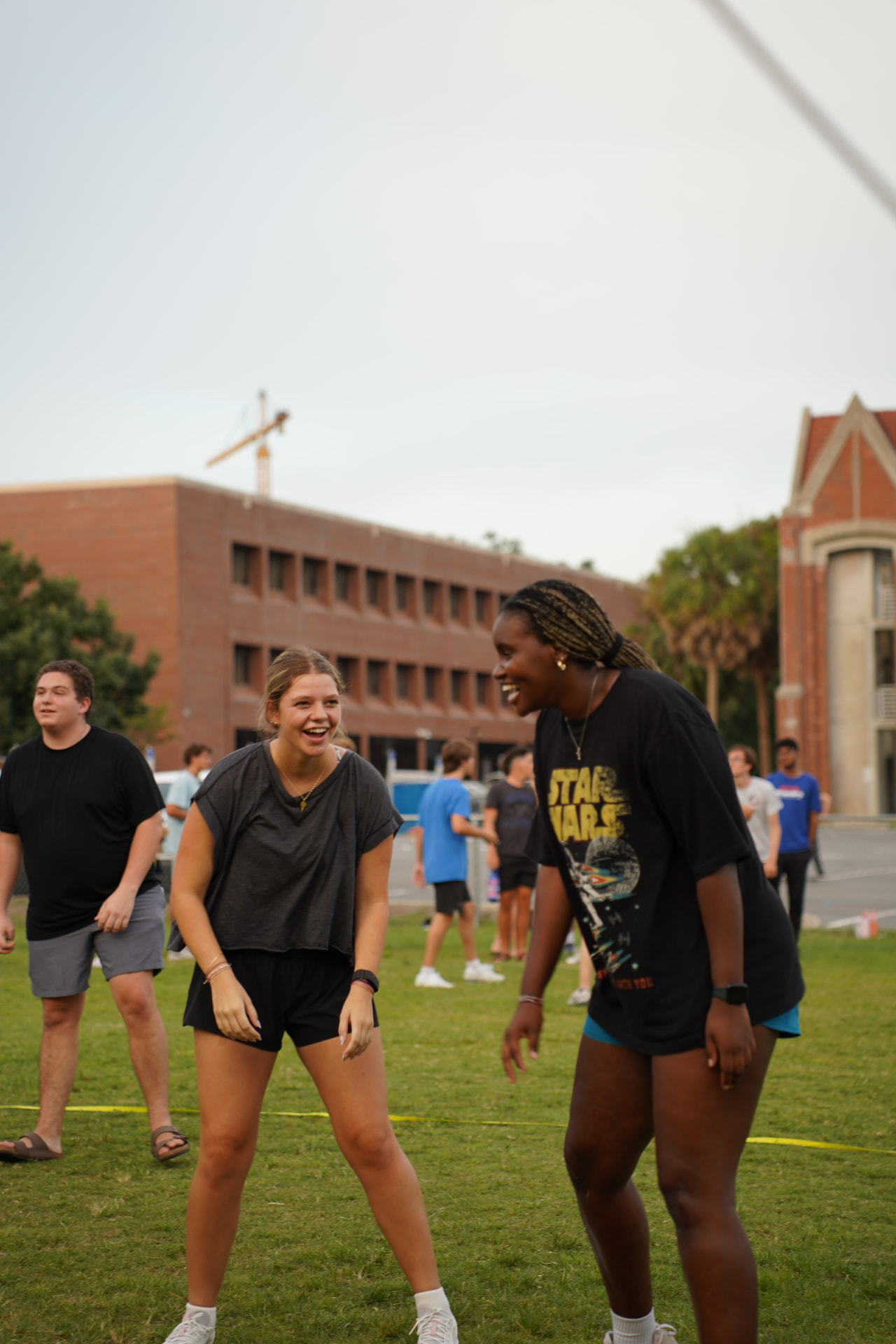 Students laughing together at an outdoor campus game night